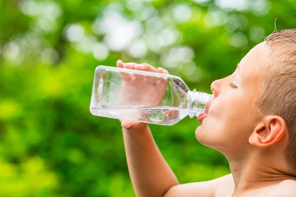 Child drinking clean tap water from transparent plastic bottle — Stock Photo, Image