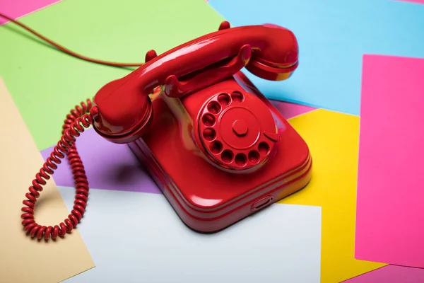 Telefone retro vermelho sobre fundo colorido e pastel — Fotografia de Stock