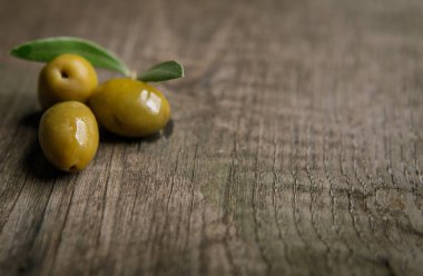 Zeytin ve üzerinde bir dokulu yıpranmış ahşap yalan şube sur masa