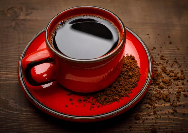 Uma xícara vermelha de café instantâneo saboroso, na superfície de madeira — Fotografia de Stock