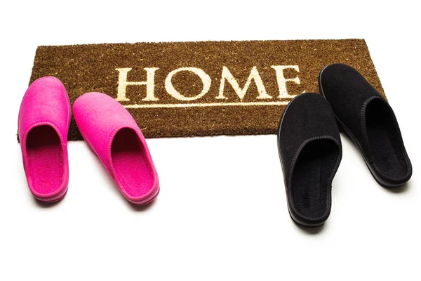 Brown carpet doormat with text Home and slippers. — Stock Photo, Image