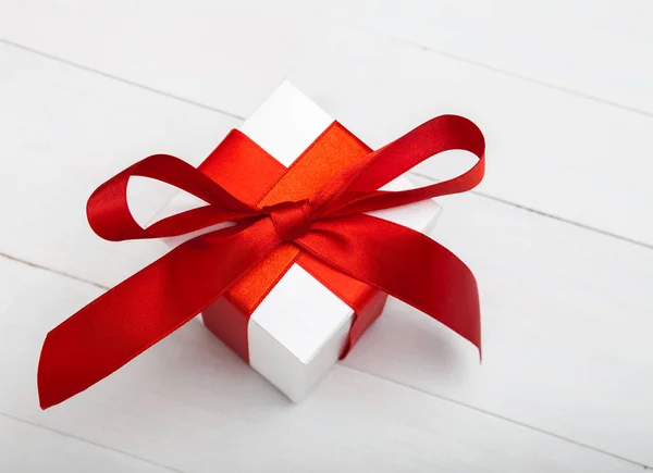 Coffret cadeau avec ruban rouge, sur le fond en bois blanc, clippi — Photo