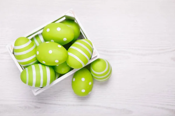 Top view of colorful easter eggs in white basket. Easter backgro — Stock Photo, Image