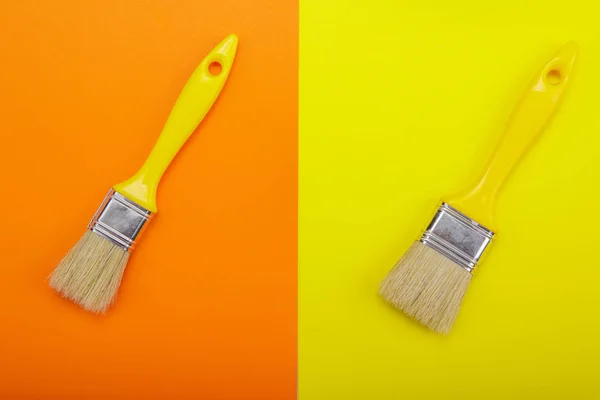 Two Yellow paintbrush on orange end yellow background — Stock Photo, Image