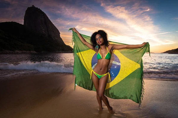 Menina com bandeira brasileira na praia — Fotografia de Stock