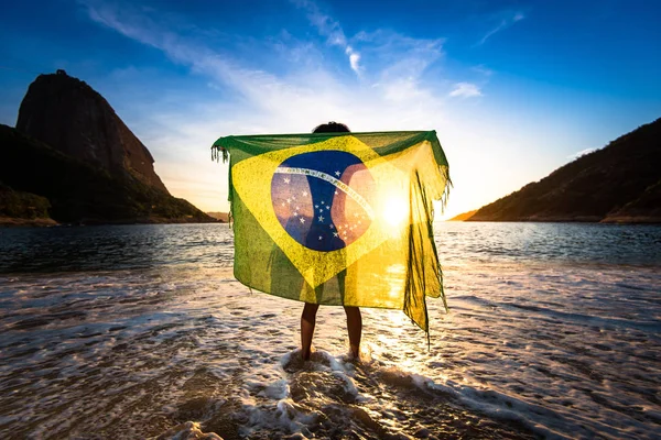 Chica con bandera brasileña en la playa — Foto de Stock