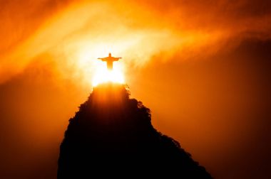 Rio de Janeiro, Brazil - January 17, 2018: The famous Rio de Janeiro landmark - Christ the Redeemer statue on Corcovado mountain. Silhouette by sunset. clipart