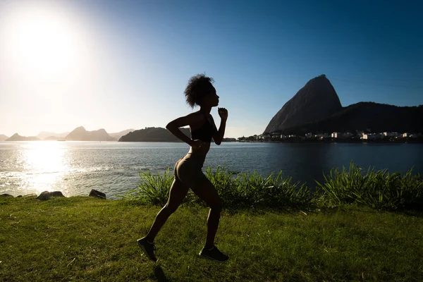 Silhouette of Fitness Woman Running by Sunrise, Sugarloaf Mountain in the Horizon