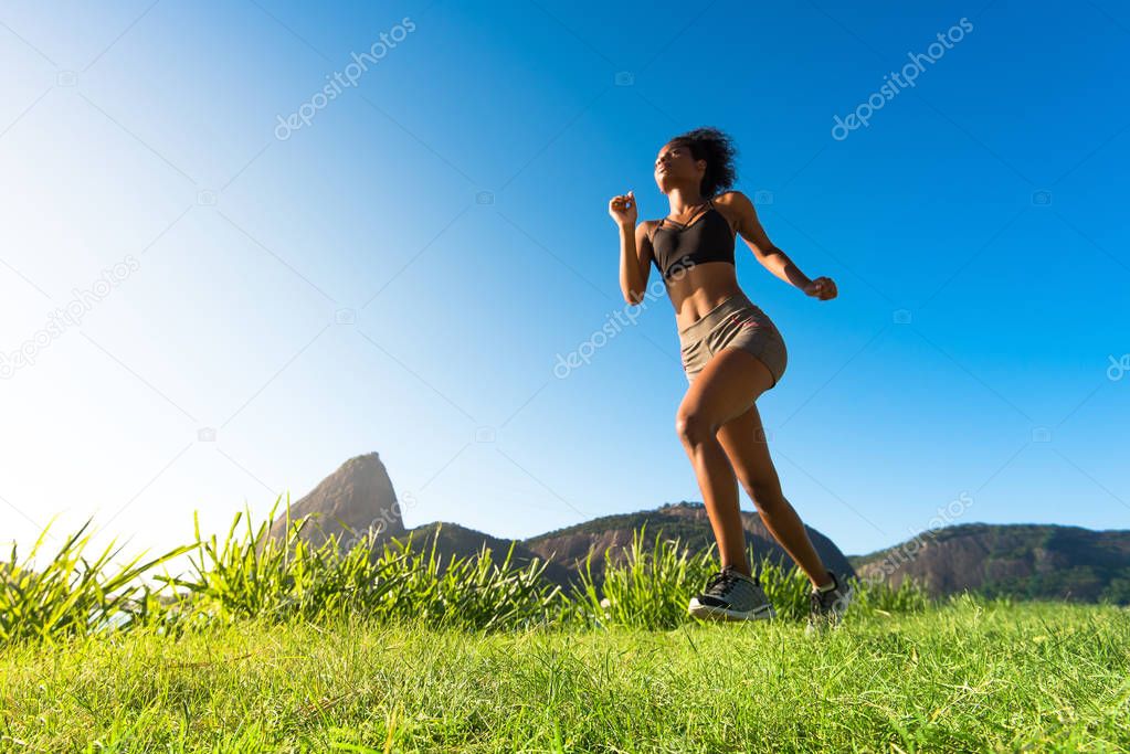 Young Attractive Fitness Woman Running in Meadow in the Morning