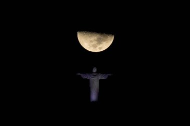 Kurtarıcı İsa, Corcovado Dağı 'nın tepesinde ve Ay geceleri tam arkasında.