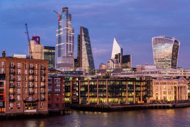 Thames Nehri 'nin Önündeki Apartman Binaları ve Londra şehrinin Günbatımındaki Modern Binalar