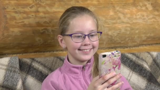 Teen Girl Lee Libro Smartphone Ríe Sofá Cubierto Con Una — Vídeo de stock