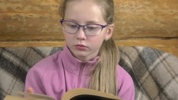 Teen Girl Reads Book Smartphone Laughs Sofa Covered Warm Woolen — Stock Video
