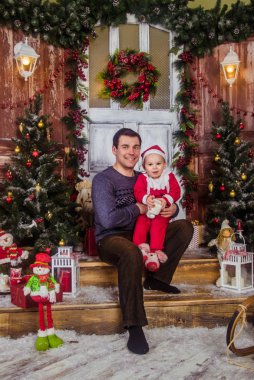 Noel Baba şapkalı mutlu baba, Noel Baba kılığında küçük oğluyla oynuyor..