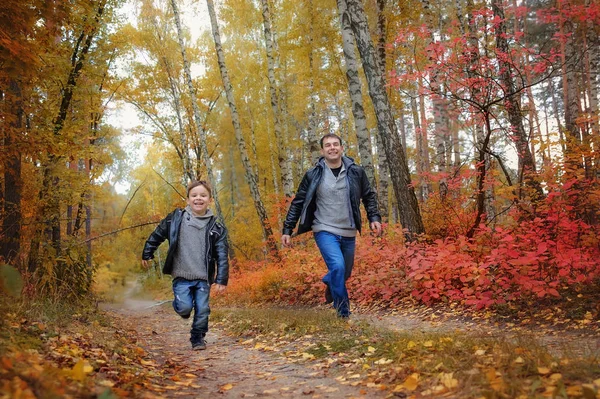 Far och son spelar på parken eller skogen under hösten — Stockfoto
