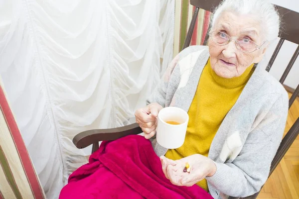 Ældre dame tager medicin - Stock-foto