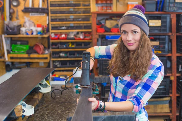 Pretty girl repairing ski in the workshop — Stock Photo, Image