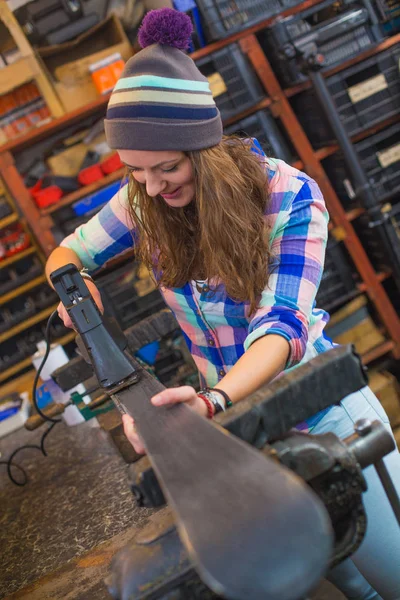 Pretty girl repairing ski in the workshop — Stock Photo, Image