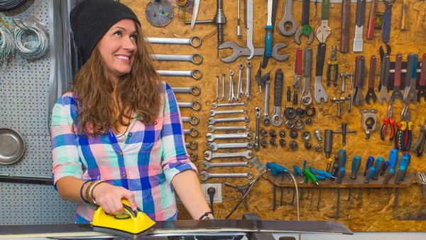 Pretty girl waxing ski in the workshop — Stock Photo, Image