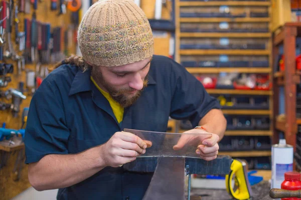 Bearded guy doing handicrafts in the workhop — Stock Photo, Image