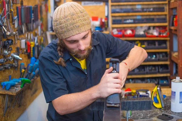 Bearded guy repairing ski in the workshop — Stock Photo, Image