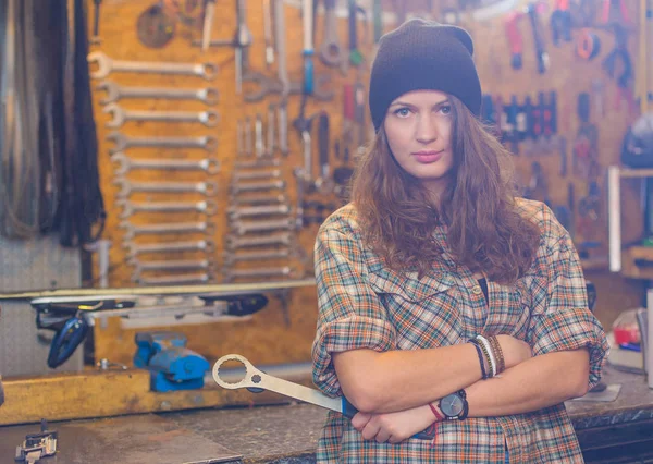 Pretty girl in the workshop with a tool — Stock Photo, Image