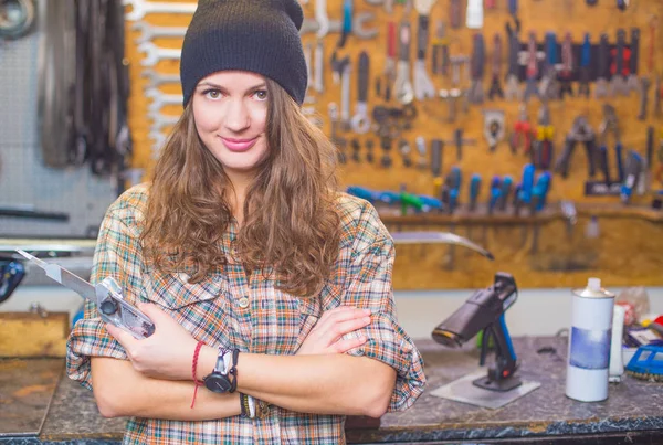 Pretty girl in the workshop with a tool — Stock Photo, Image