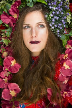 Kafasında çiçekler olan genç bir esmer.