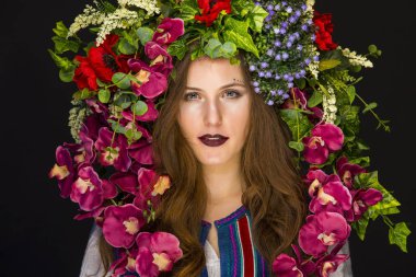 Kafasında çiçekler olan genç bir esmer.