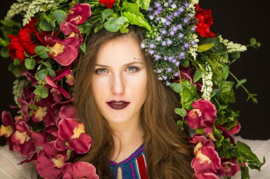 Kafasında çiçekler olan genç bir esmer.