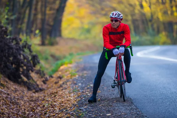 Genç Iyi Donanımlı Bir Adam Yarış Bisikletiyle Yol Kenarında Duruyor — Stok fotoğraf