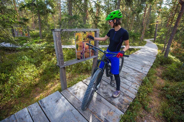 美丽的女人站在木制森林小径上 骑着自行车 — 图库照片