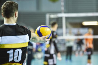 Voleybol oyuncusu topu servisten önce tutuyor.