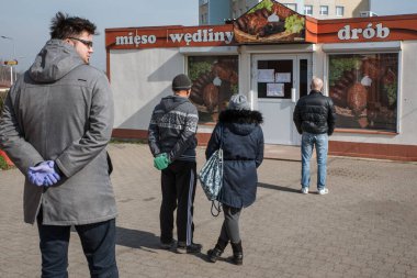LUBIN, POLAND - 16 Mart 2020. Mağazanın önünde kuyrukta bekleyenler Polonya 'da 