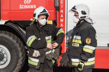 DZIESLAW, POLAND - 6 Nisan 20209 - Yangın söndürme eylemi sırasında Covid-19 nedeniyle Msk 'e bakan itfaiyeciler.
