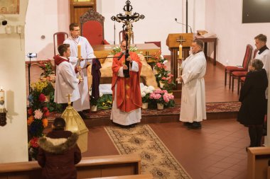 TYMOWA, POLAND - 10 Nisan 2020. Kilisedeki Tutku Ayini. Kutsal Cuma günündeki Kraliçemiz. Rahip haç tutuyor..