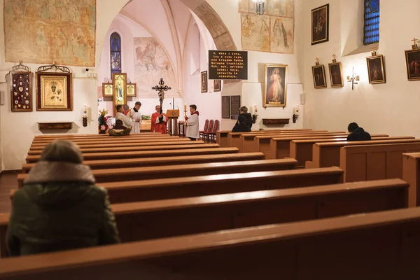 TYMOWA, POLAND - 10 Nisan 2020. Kilisedeki Tutku Ayini. Kutsal Cuma günündeki Kraliçemiz. Elinde haç tutan bir rahip. Covid-19 salgınından dolayı kilisede sadece 5 inançlı insan olabilir..