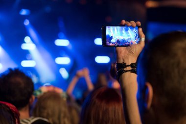 Konserde video ya da fotoğraf çeken adam..