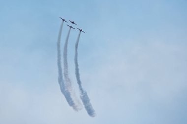 Hava gösterisi sırasında mavi bulutlu gökyüzünde uçaklar oluşacak..