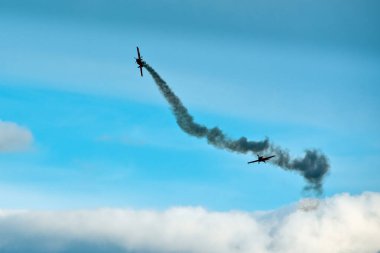 Hava gösterisi sırasında mavi bulutlu gökyüzünde iki uçak.