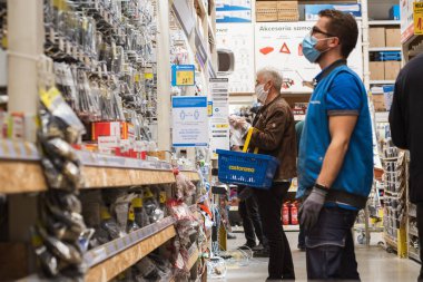 LUBIN, POLAND - 21 Nisan 2020. Castorama 'daki süpermarket binasında Coronavirüs salgınından dolayı maskeli müşteriler,  