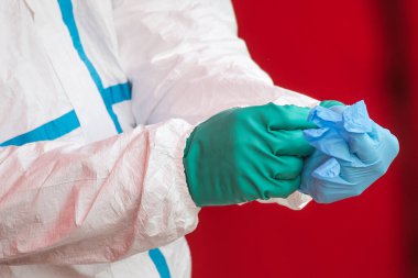 Tıbbi personel, Coronavirus Sars-Cov-2 içeriğini test etmeden önce tek kullanımlık eldivenler giyer..