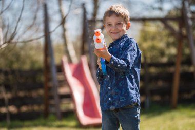 Çocuk Paskalya 'da su tabancasından su fışkırtıyor.