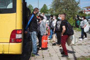 LUBIN, POLAND - 9 Mayıs 2020. İnsanlar otobüs durağında inip otobüse biniyorlar..