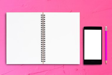 Defter ve pembe bir arka plan üstünde hareket eden telefon