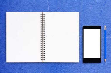 Defter ve mavi arka plan üstünde hareket eden telefon