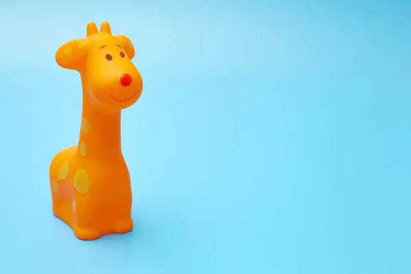Childrens rubber orange toy on a blue background with a copy space