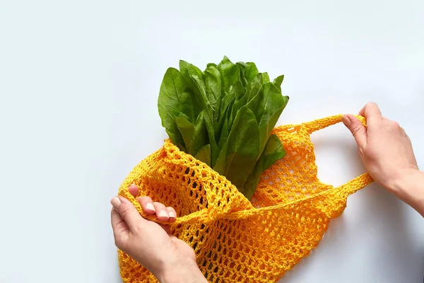 Young womans hands put salad cotton grocery bag. Reusable eco bag for shopping. Zero waste concept. — Stock Image Young womans hands put salad cotton grocery bag. Reusable eco bag for shopping. Zero waste concept. Stock Picture