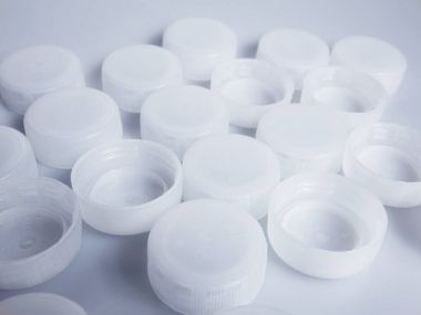 Beyaz Kağıt arka plan üzerinde beyaz plastik şişe kapakları kümesi