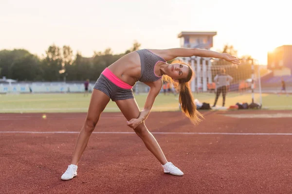 Uygun kadının yan bend germe egzersiz yapması